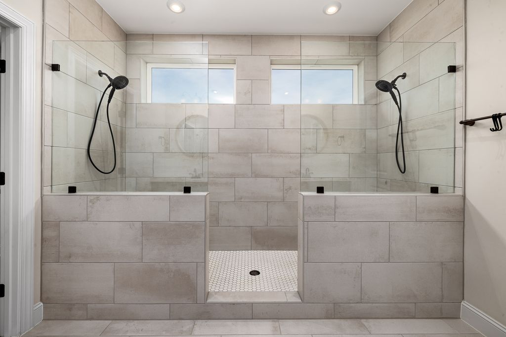A sleek, contemporary dual shower bathroom featuring elegant tile work and modern fixtures.